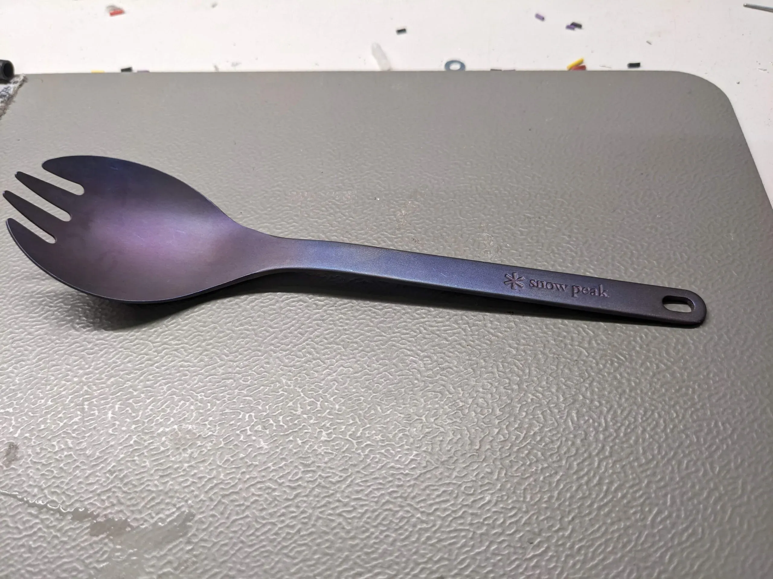 A purple spork with a blue sheen